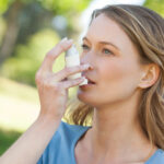 Asthma Patient girl inhaling from inhaler