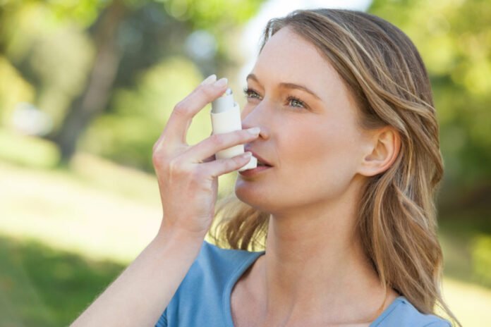 Asthma Patient girl inhaling from inhaler