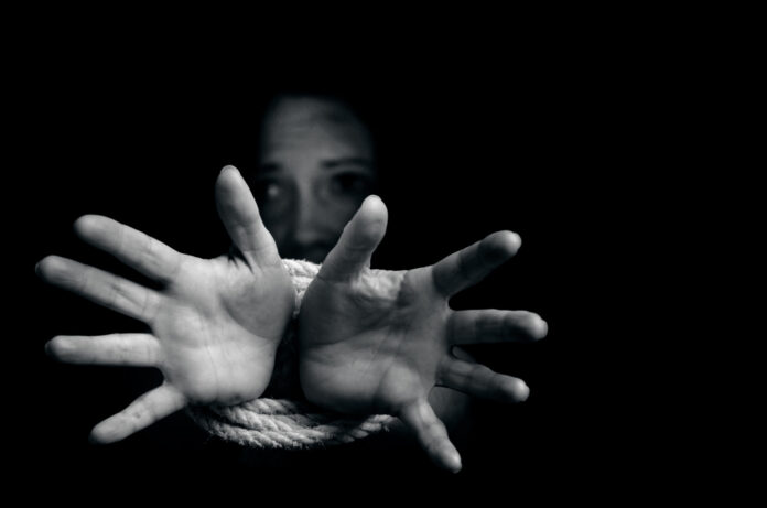 Girl with tied hands in dark
