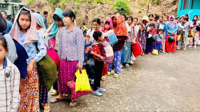 Myanmar refugees line up at a relief shelter in Mizoram as biometric registration plans are prepared