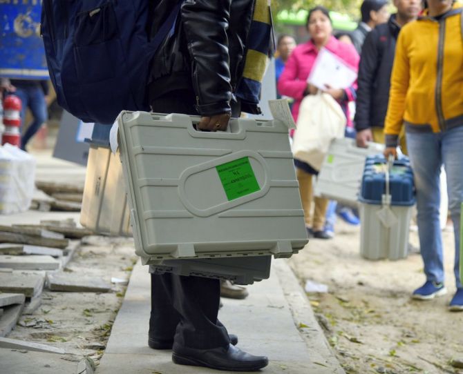 Electoral staff members carry the EVM and VVPAT machines ahead of elections