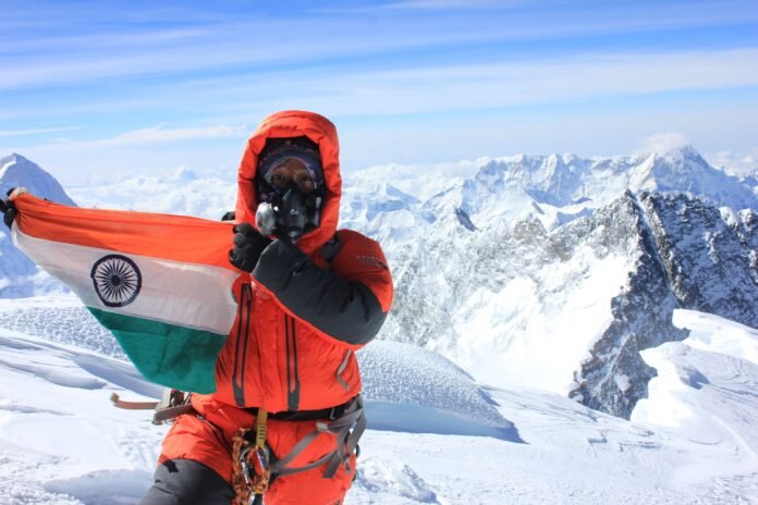 Assam’s first woman Everest climber standing triumphantly at the summit of Mount Everest after completing a historic all-women expedition.