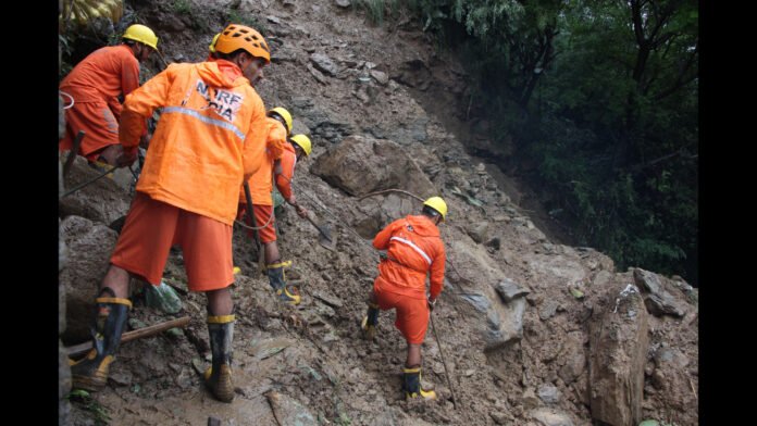 Rescue teams near the site of the Migging Landslide Fatalities Incident after a vehicle plunged down a steep hillside.