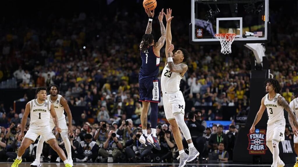 Michigan Wolverines and UConn Huskies players competing during a high-profile college basketball game at TD Garden.