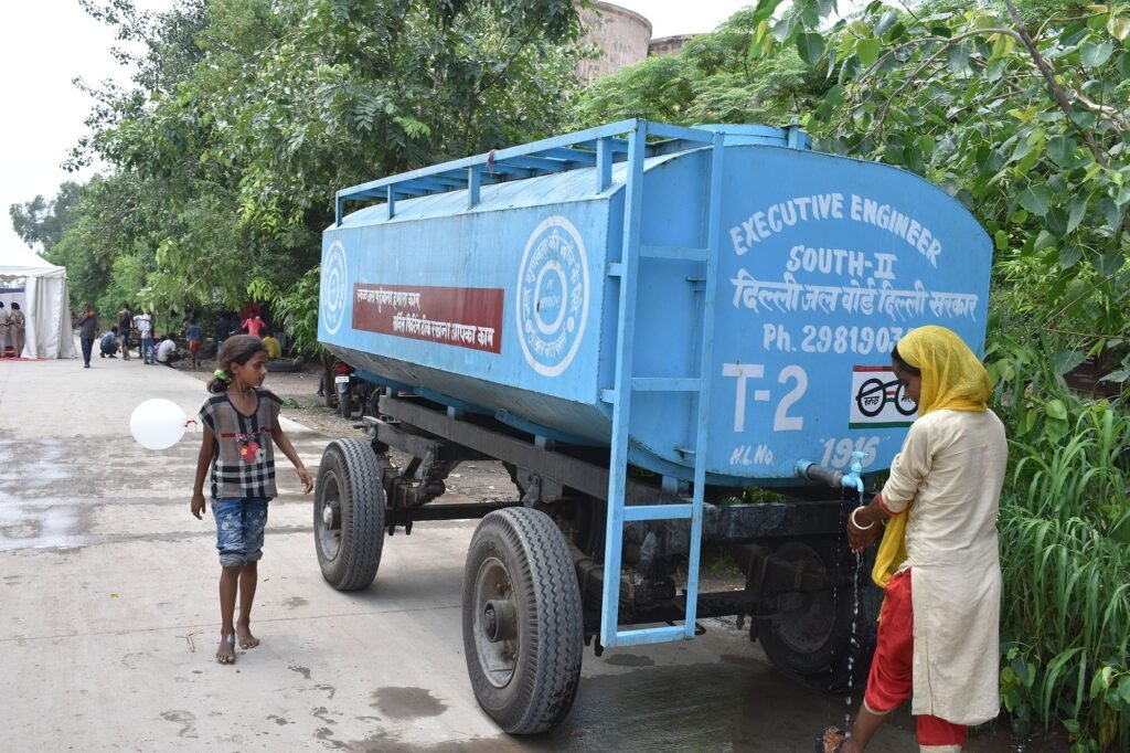 A mobile water purification truck supplies clean drinking water to residents at a flood-affected relief camp in a remote area during ongoing monsoon relief operations.
