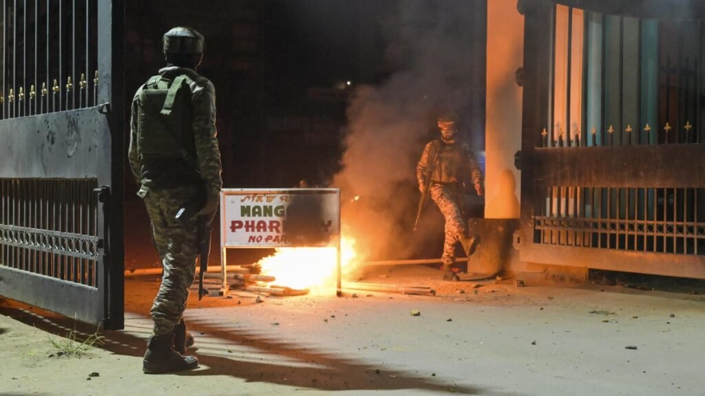 Security personnel patrol a border village in Kamjong district after reports of houses being burned during a violent incident.