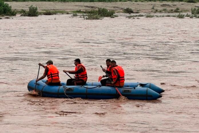 SDRF personnel remain on standby near a riverbank with rescue equipment as authorities strengthen emergency preparedness during the monsoon season.