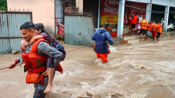 Students arrive at a school during rainy weather after education authorities revise school timings in flood-prone areas.